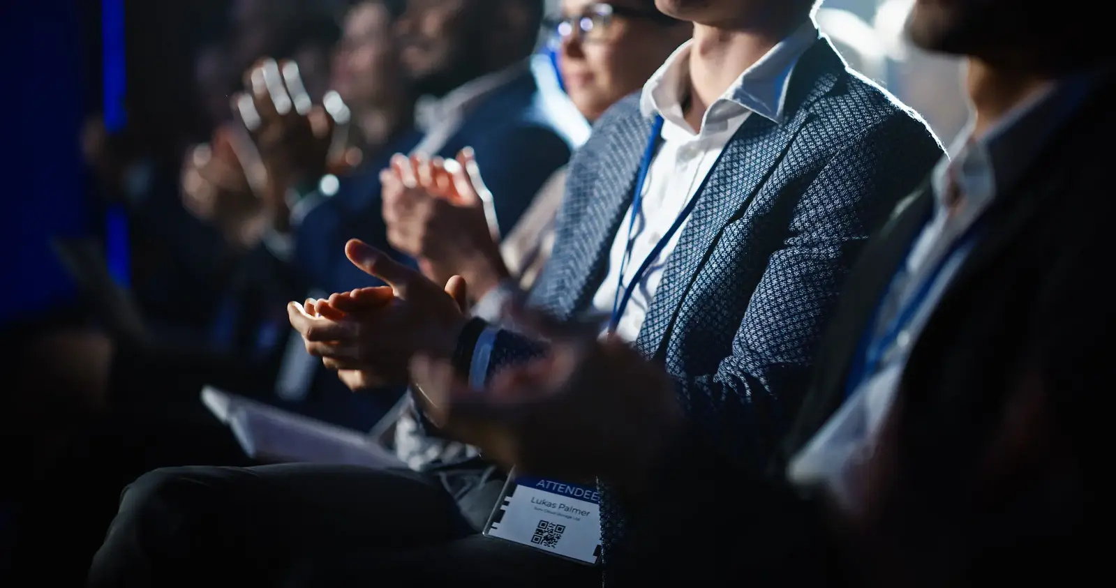 people in suits clapping during event